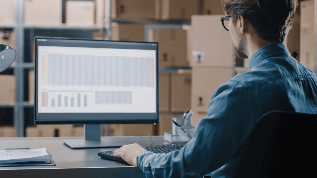 A man looking at a complex spreadsheet on a computer.